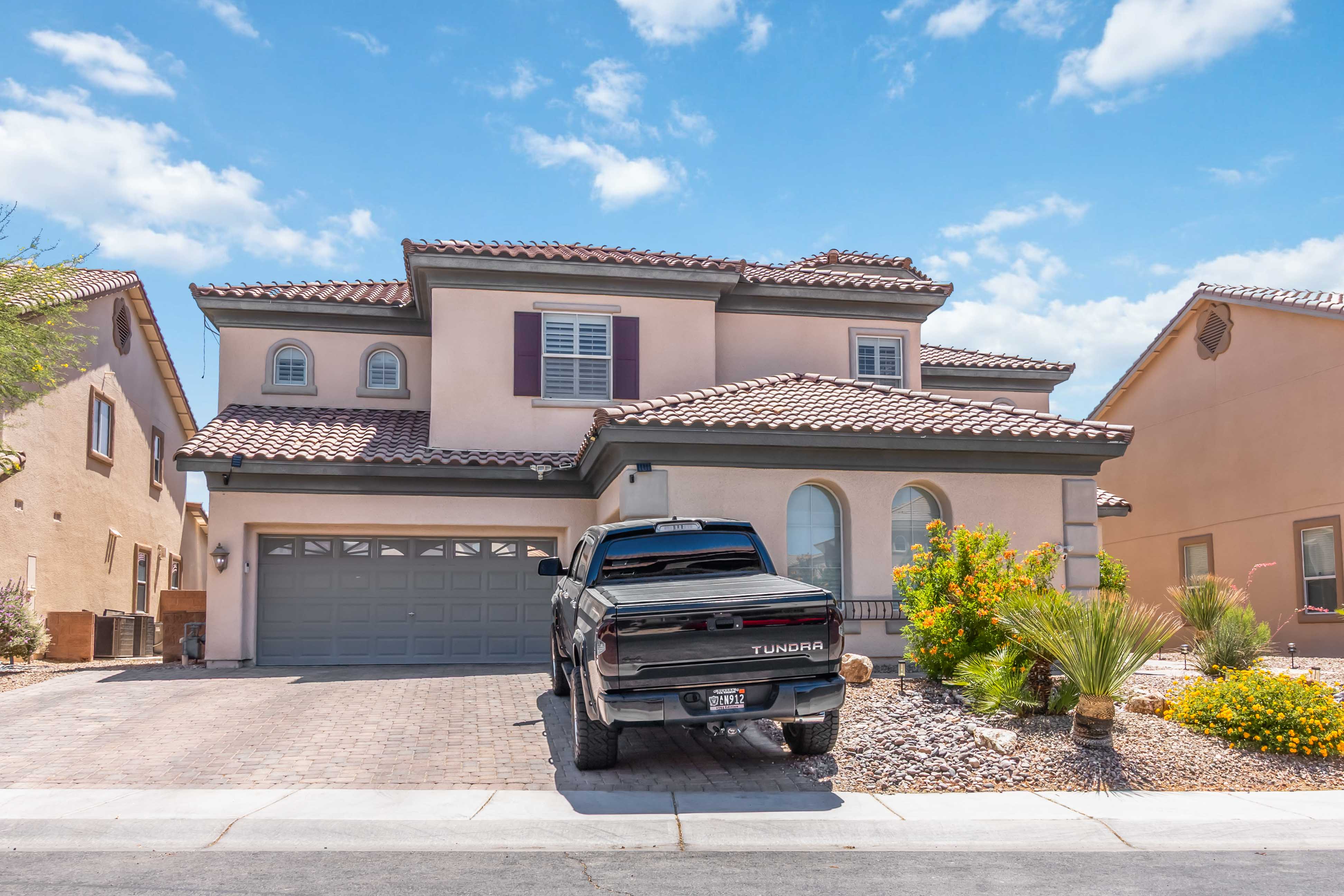 Front facade of 9564 Trattoria Street showing the garage, entry, and landscaping