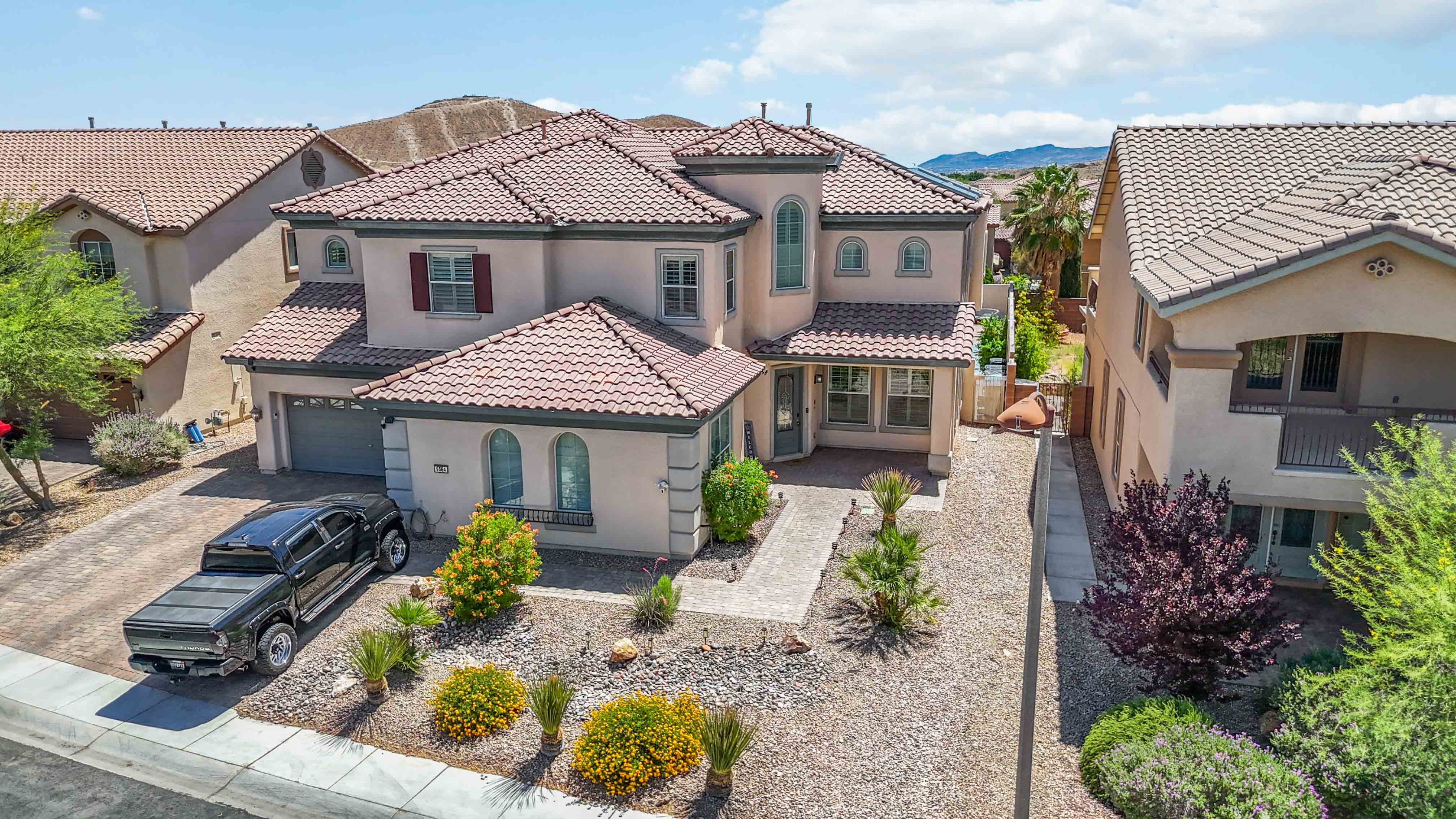Front aerial angle of 9564 Trattoria Street centered on the full exterior and lot