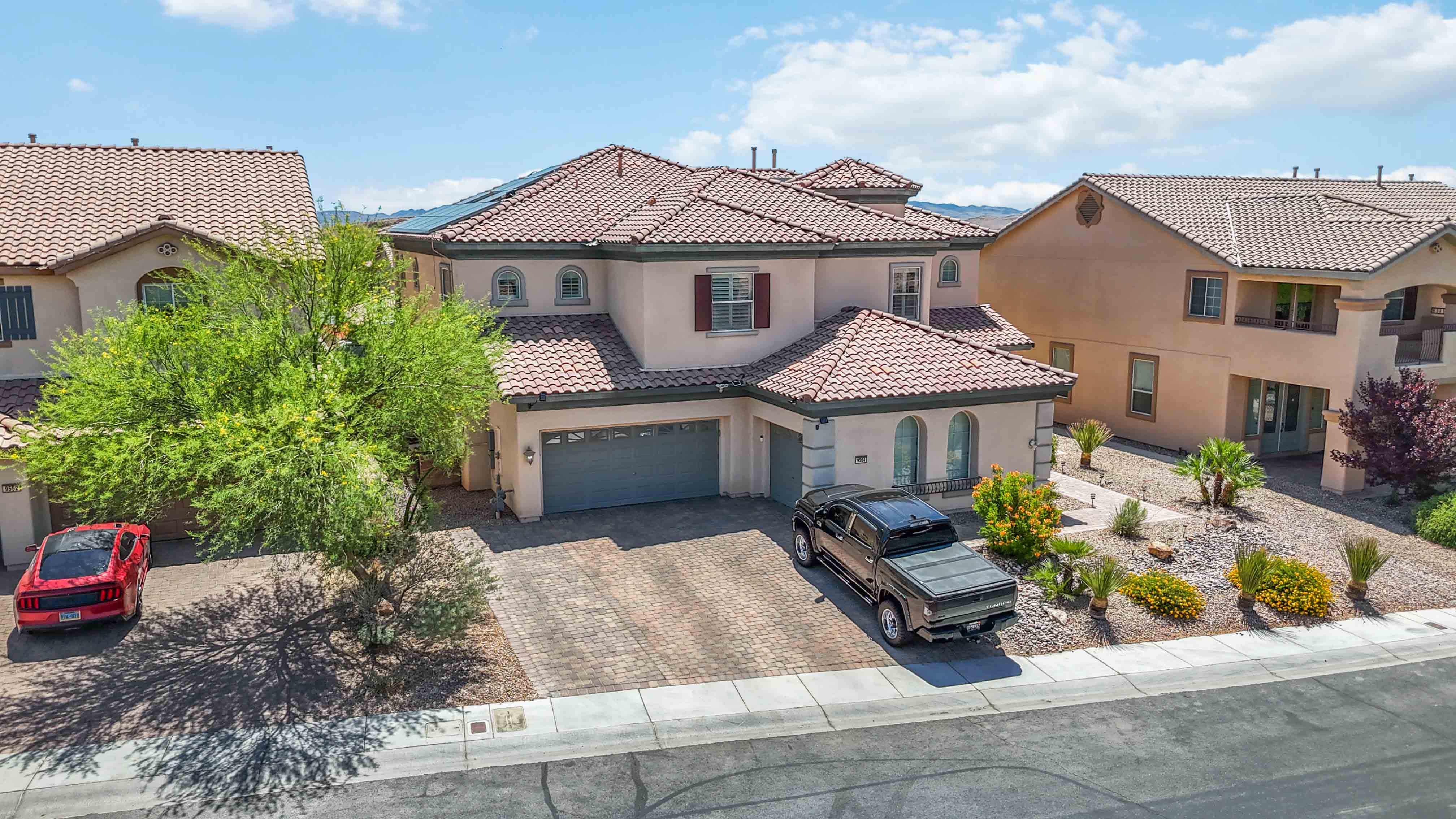 Aerial view above the backyard of 9564 Trattoria Street showing the pool and solar panels