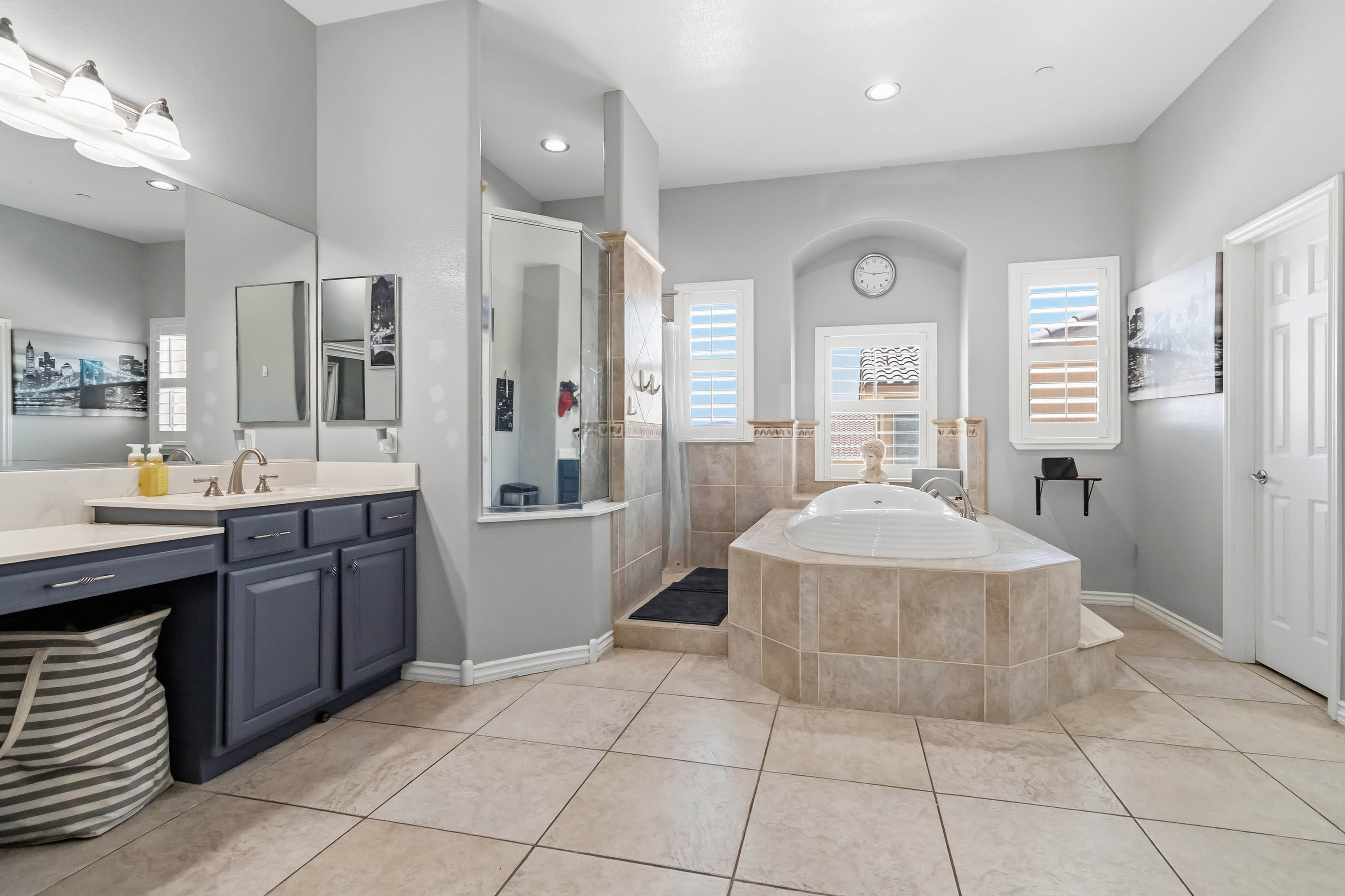 Primary bathroom at 9564 Trattoria Street with soaking tub, separate shower, and dual vanities