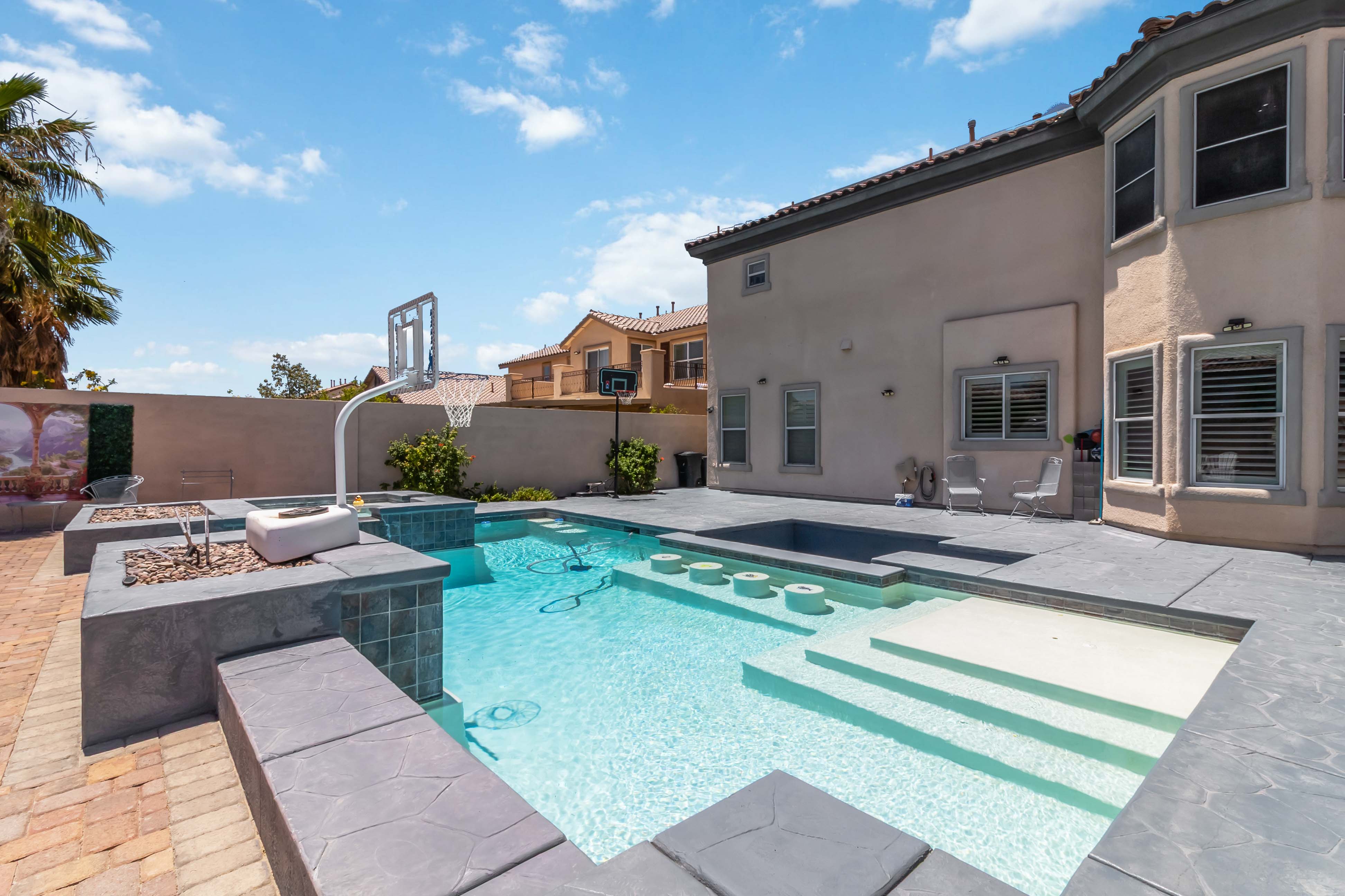 Pool detail at 9564 Trattoria Street showing the swim-up seating and tanning shelf