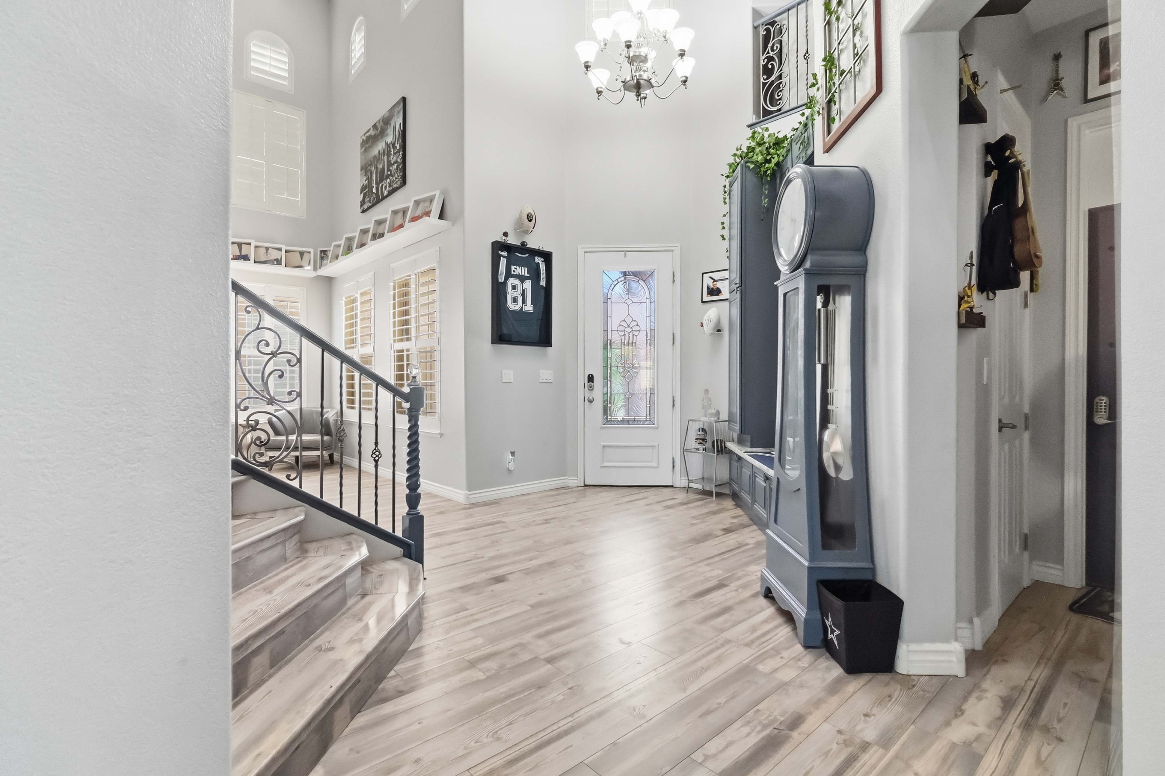 Grand foyer at 9564 Trattoria Street with staircase, tall ceilings, and wide plank floors