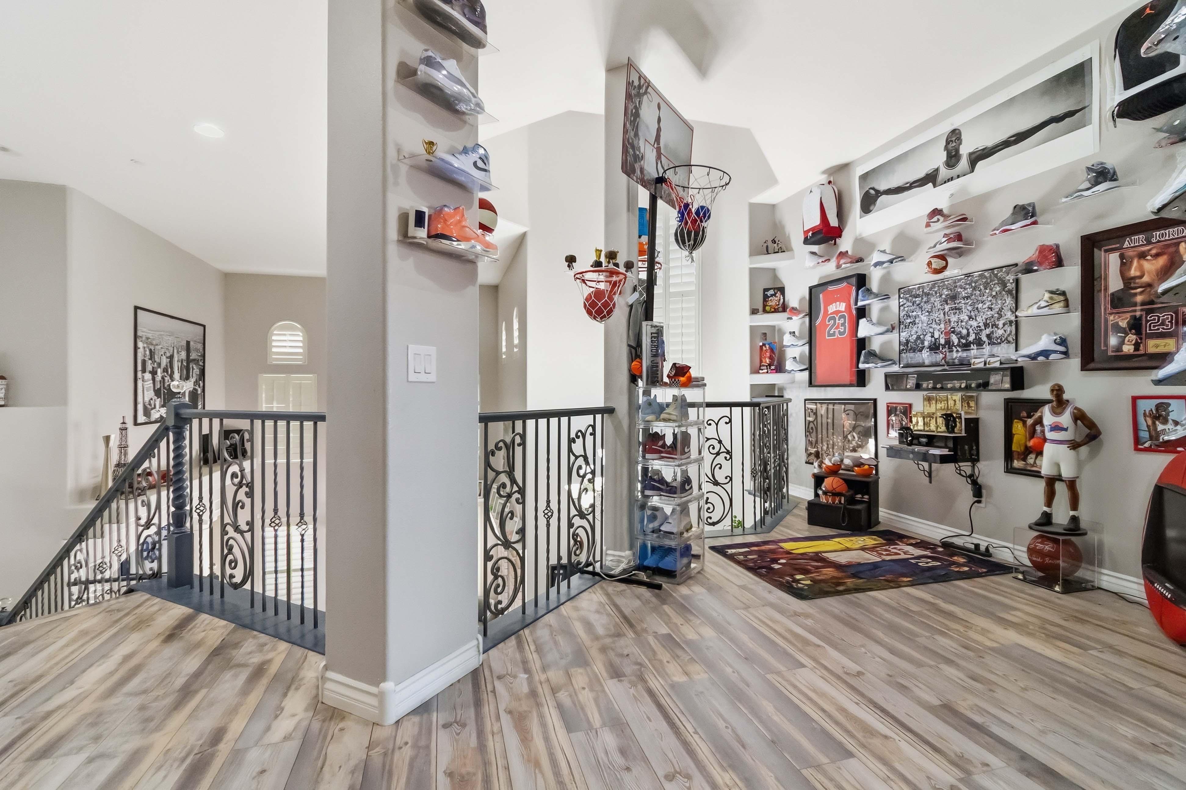 Upstairs landing at 9564 Trattoria Street with custom display wall and open railing