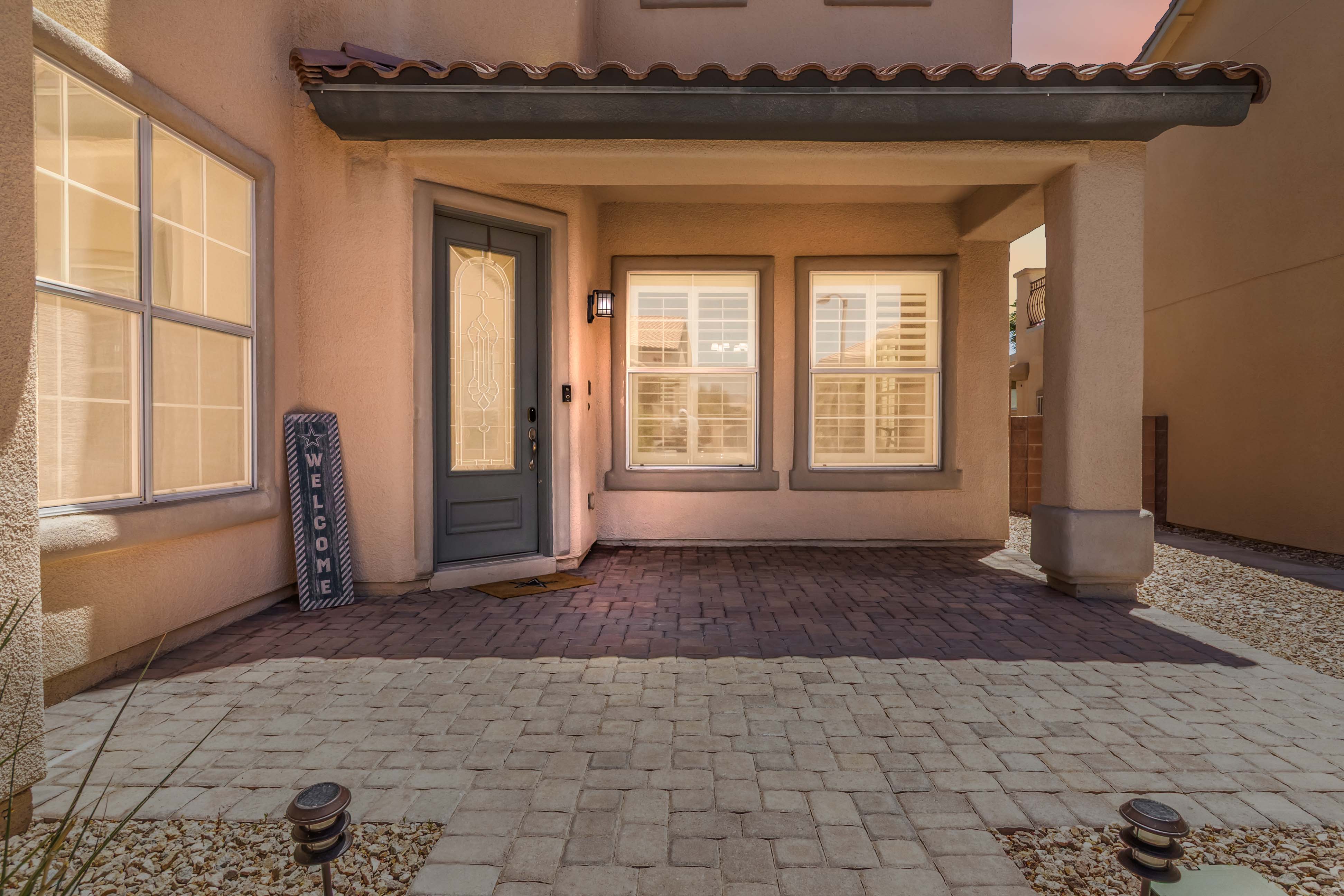 Close exterior detail of the covered front porch and glass front door at 9564 Trattoria Street