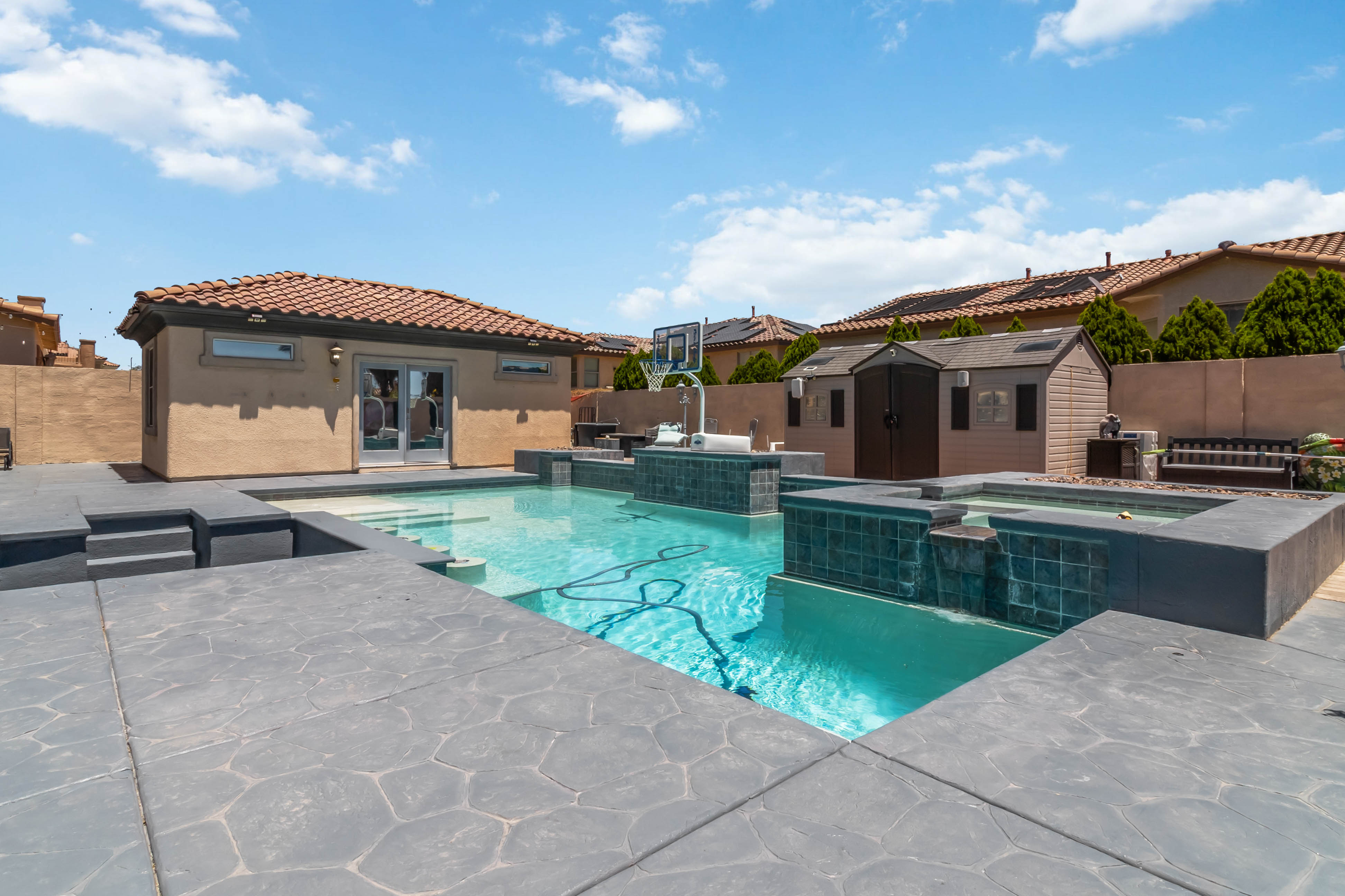 Rear exterior of 9564 Trattoria Street highlighting the pool, spa, and patio