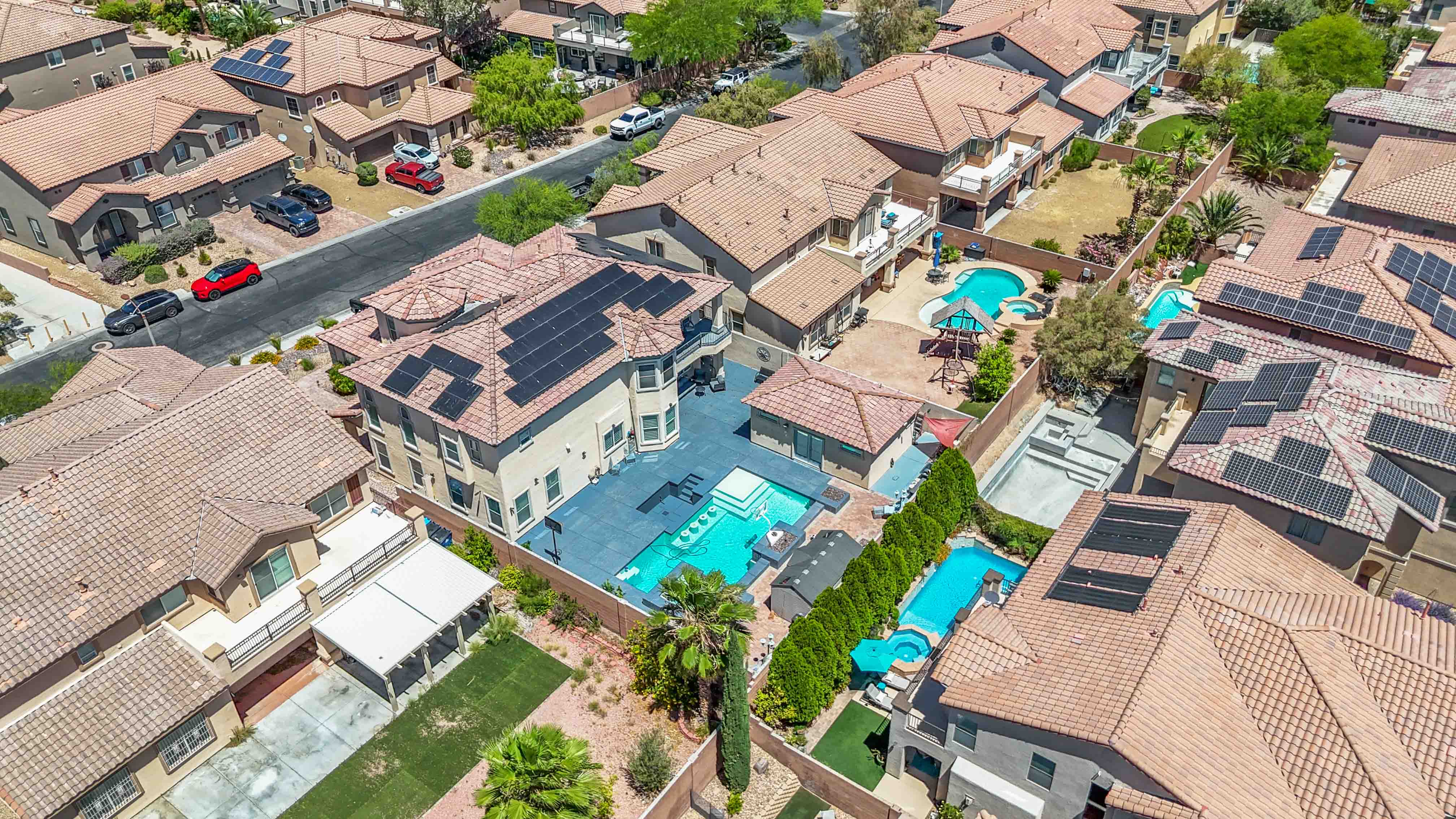 Angled aerial of 9564 Trattoria Street with pool, detached structure, and neighboring homes