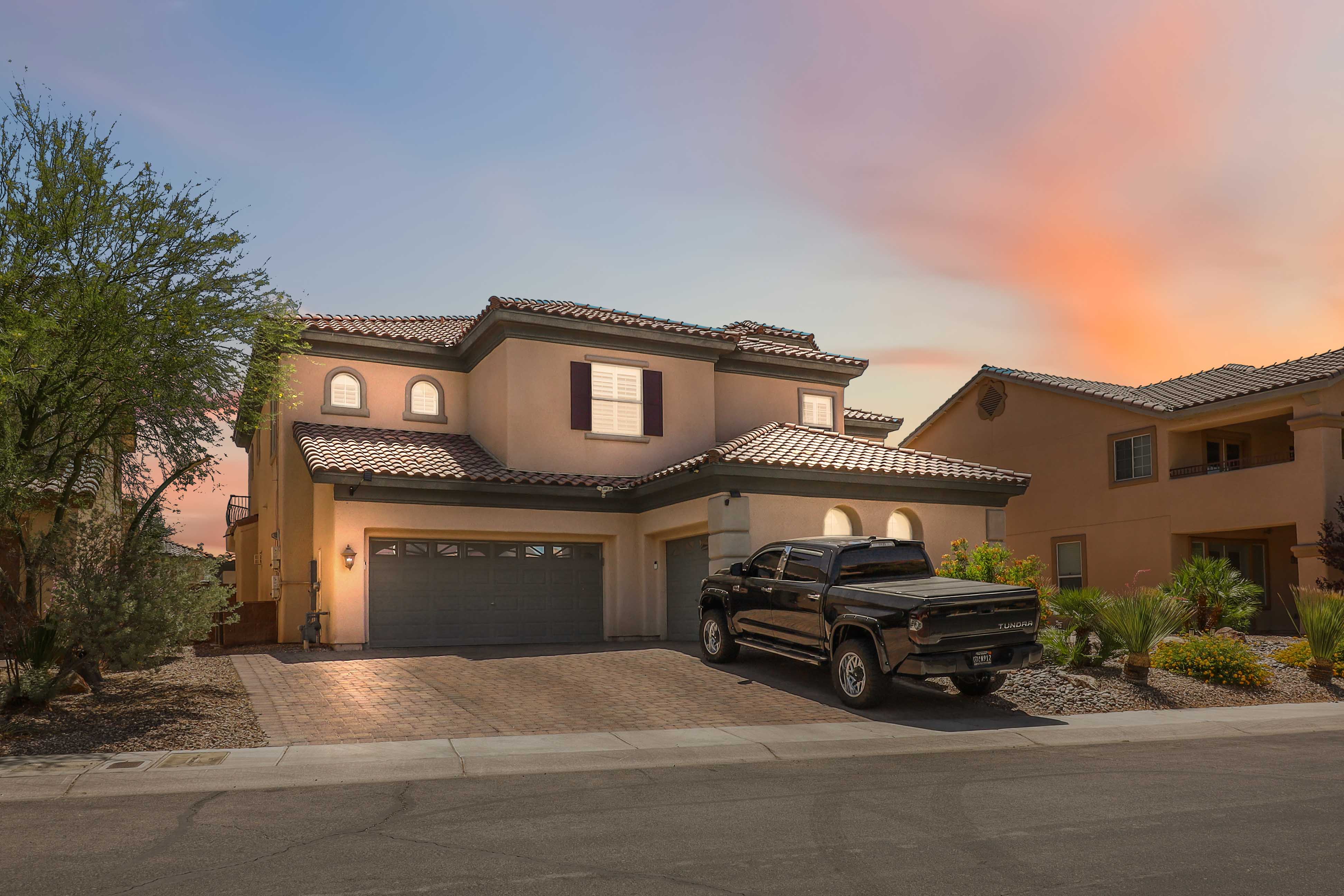 Front exterior of 9564 Trattoria Street in Las Vegas with paver driveway and desert landscaping
