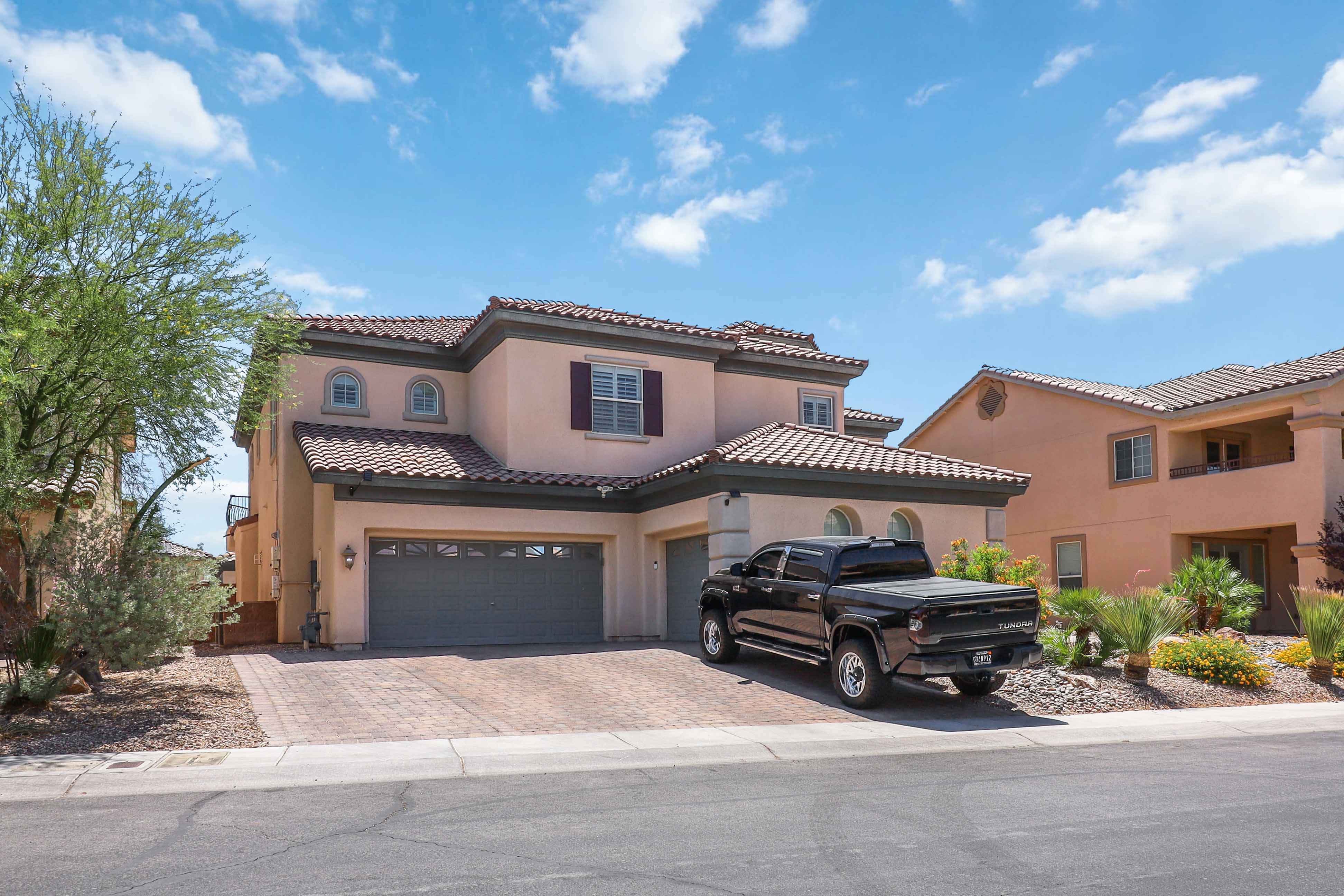 Wide front elevation of 9564 Trattoria Street with three-car garage and tile roof
