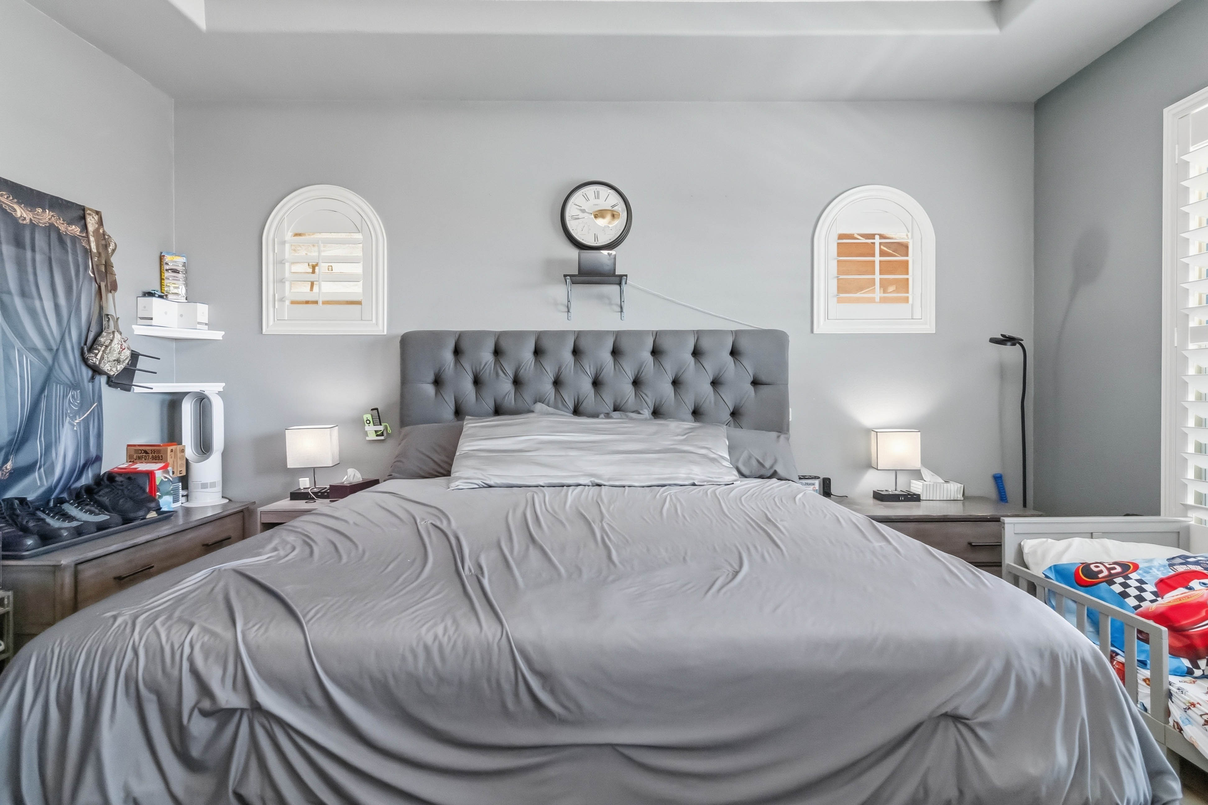 Primary bedroom at 9564 Trattoria Street with upholstered bed and arched accent windows