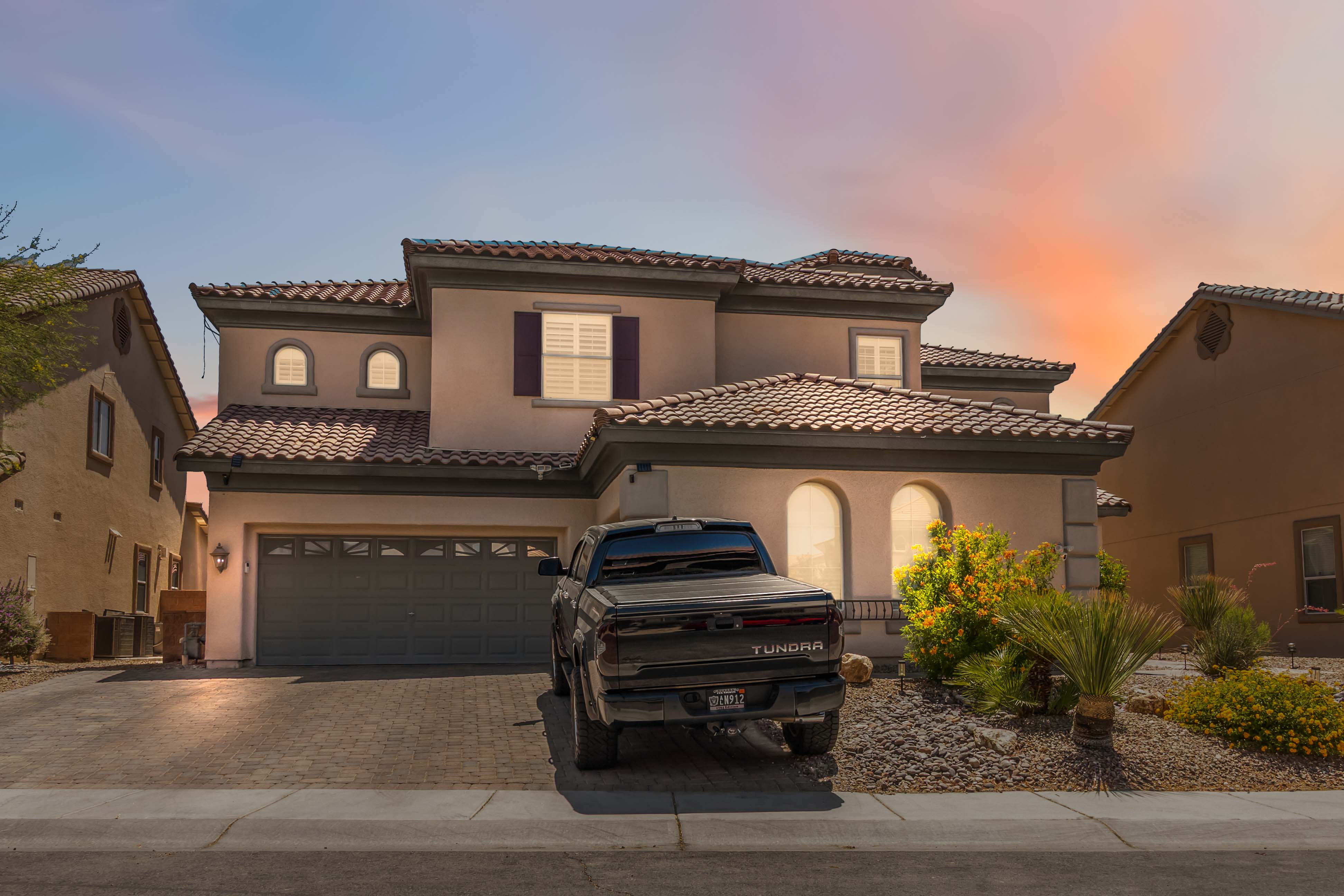 Straight-on front exterior view of 9564 Trattoria Street with mature desert landscaping