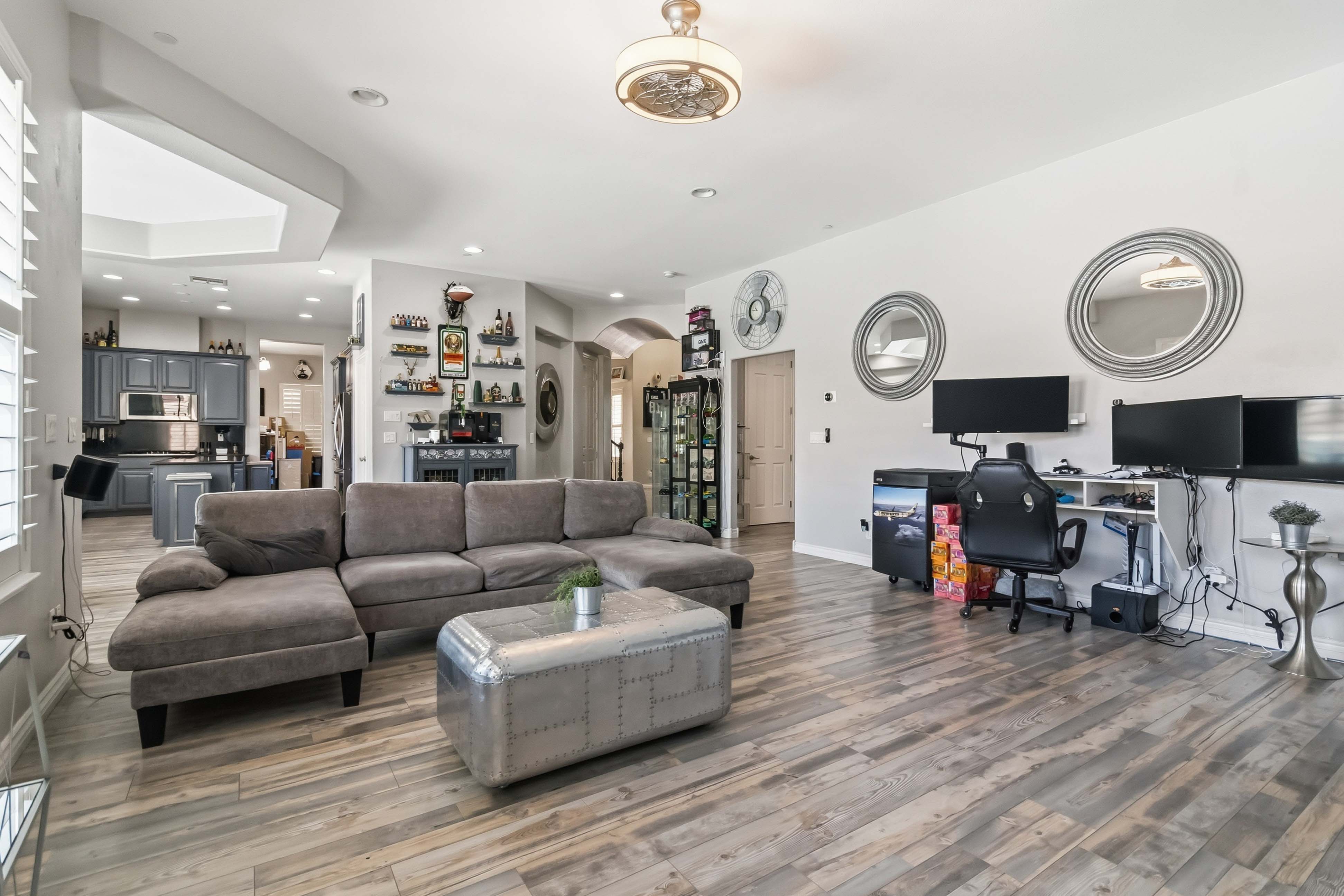 Open-concept great room at 9564 Trattoria Street connecting the living area and kitchen